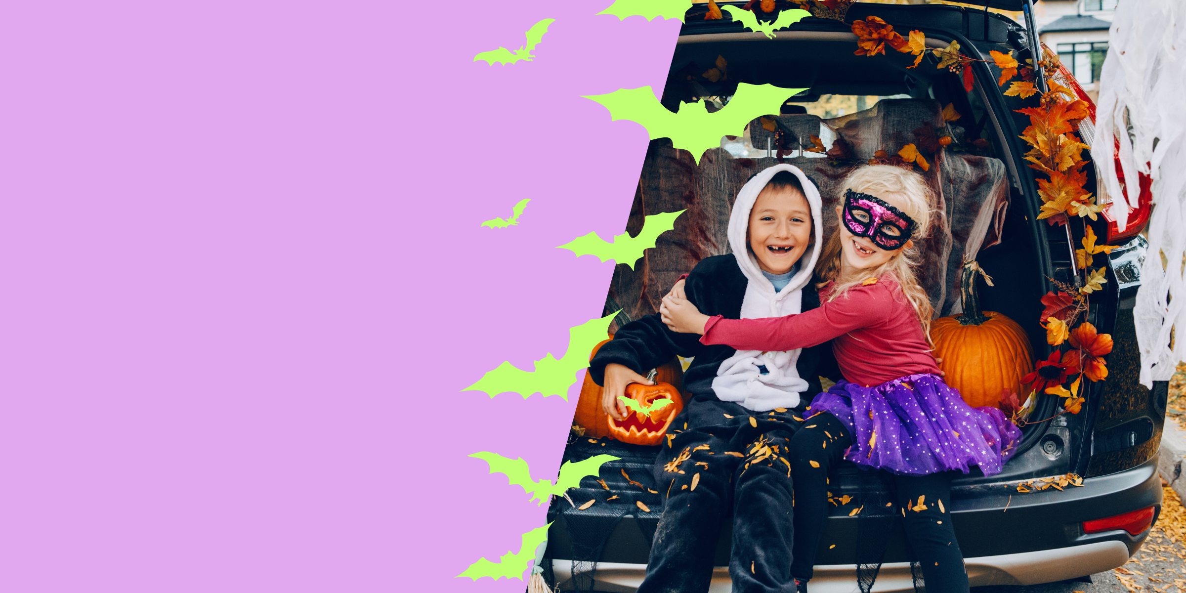 A mom and two kids in playful Halloween costumes with carved pumpkins, making silly faces